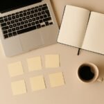 Open notebook and laptop with sticky notes showing prompt templates and marketing planning
